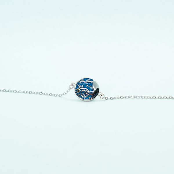 Bracelet bleu avec une lune et des étoiles jaunes, en argent avec un médaillon inspiré du tableau la nuit étoilée de Van Gogh.